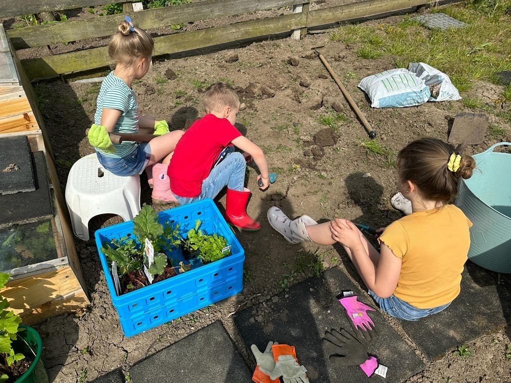 Kinderen leren samen planten en zaaien